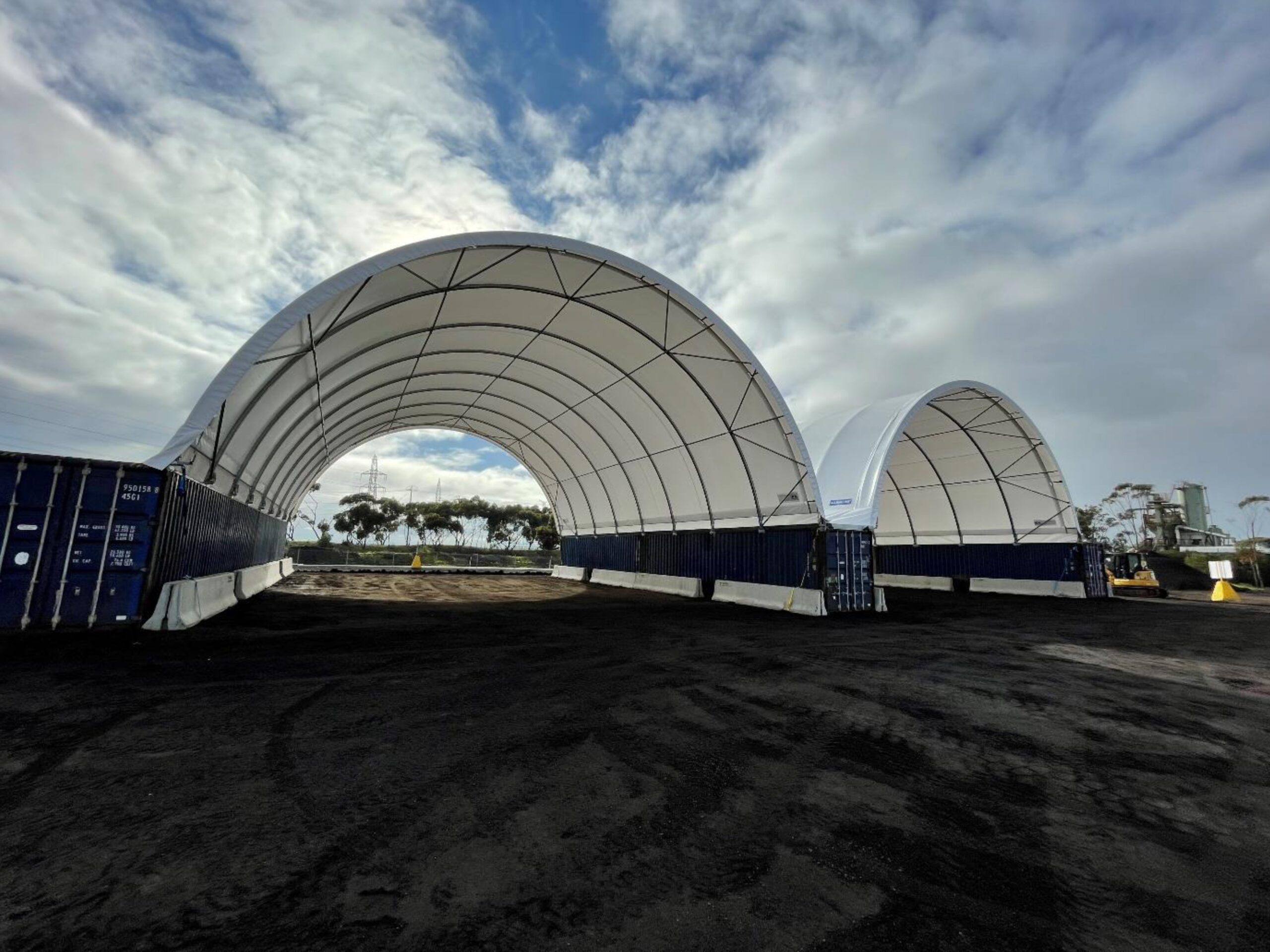 Large, open-frame dome shelters supported by containers, providing flexible and adaptable space for disaster relief, demonstrating the versatility of instant shelter solutions.