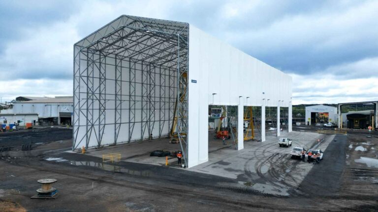 Wide side view of the completed Coronado Curragh dump truck servicing shelter in mining site.